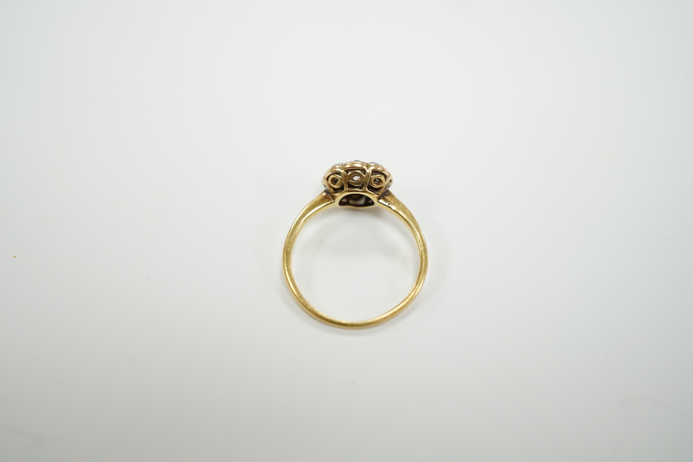 A yellow metal and diamond set flower head cluster ring, size H, gross weight 1.7 grams.